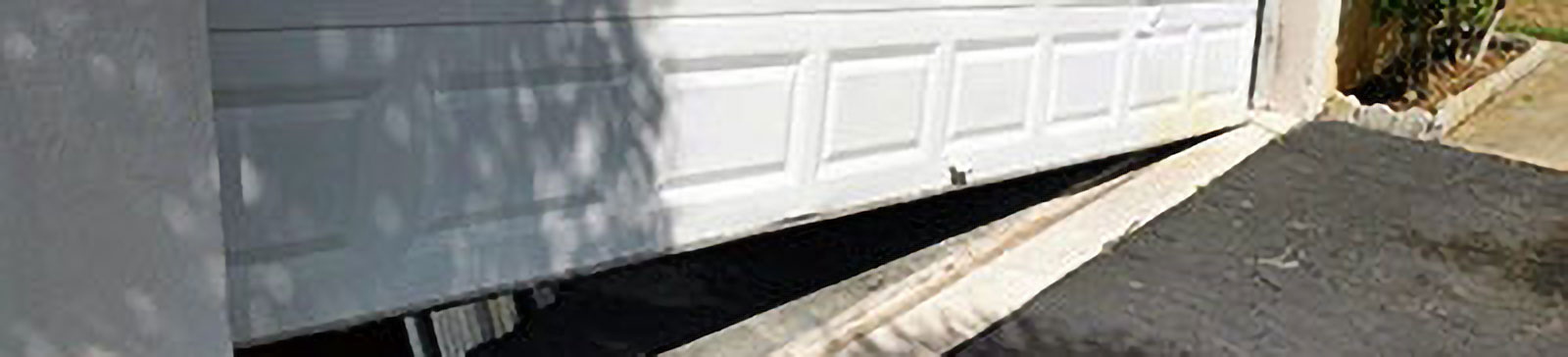Damaged sectional garage door panel with visible denting needing repair in Carpentersville
