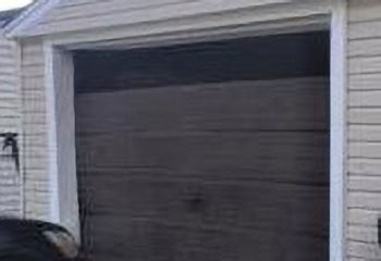 Worn wooden garage door before replacement in Crystal Lake home