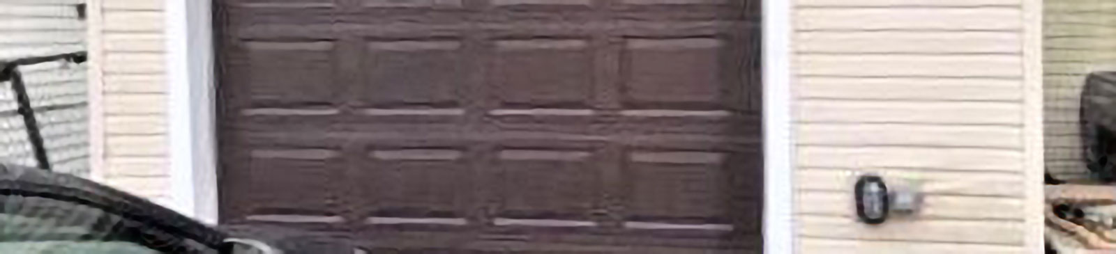 Worn wooden garage door before replacement in Crystal Lake home