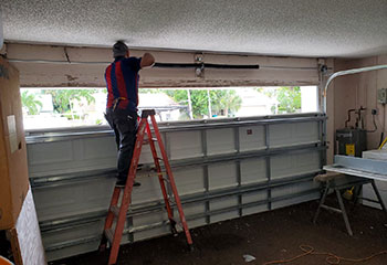 Technician checking garage door torsion spring before installation in Crystal Lake home