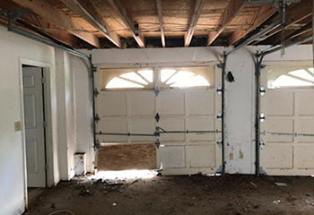 Lower panel heavily damaged on residential garage door before repair in Cary, IL